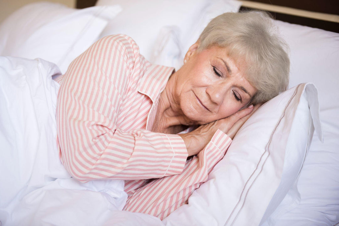 Elderly woman sleeping peacefully in bed, improving sleep during menopause