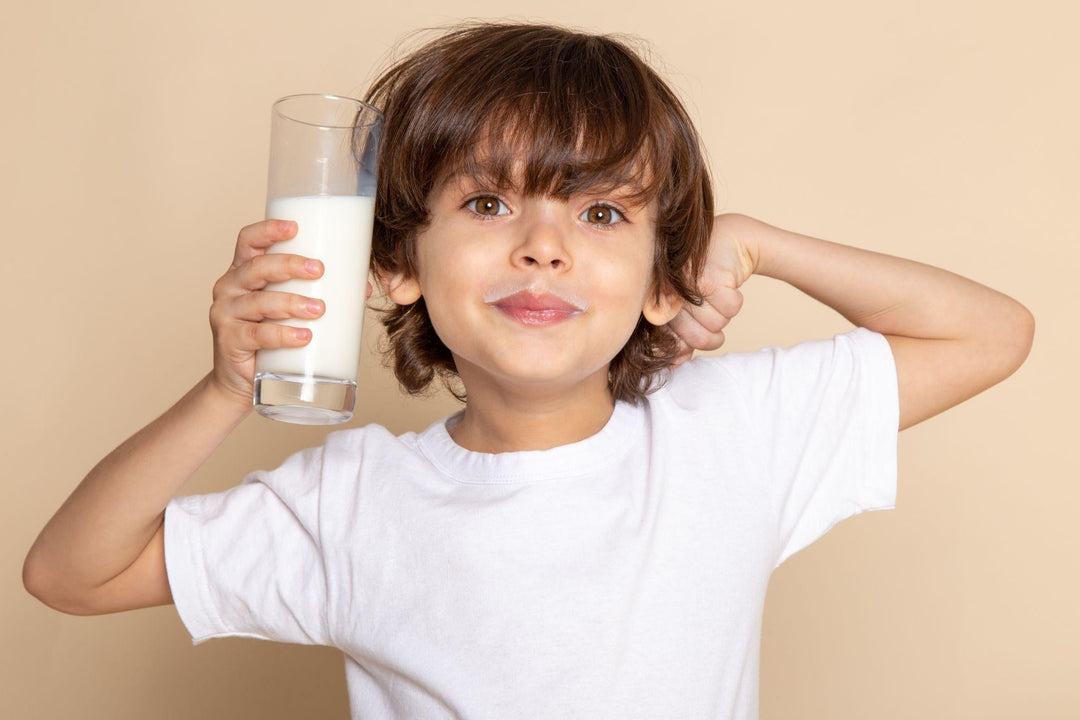 Happy child with a glass of milk promoting strong immunity and gut health supported by Clear Kids Probiotic Gummies