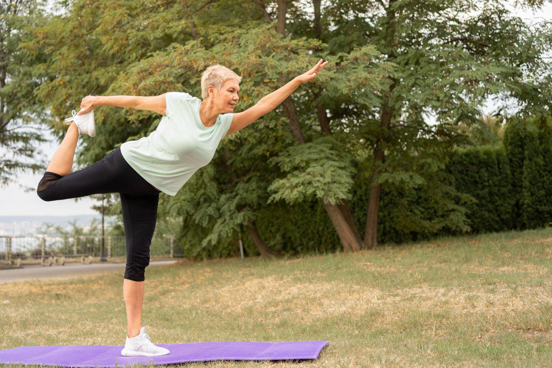 Older woman practicing yoga in a park to maintain joint flexibility and mobility with age